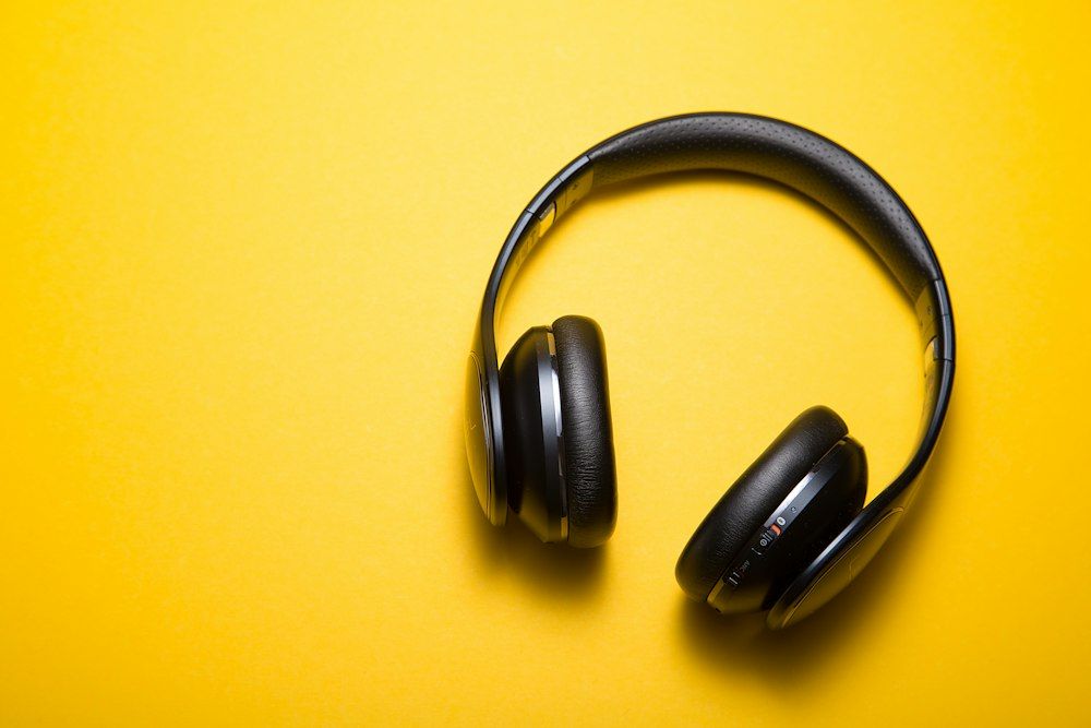 Black over-ear headphones on yellow